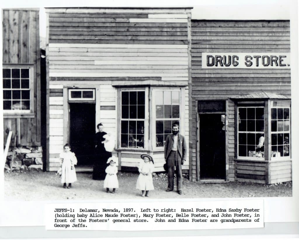 A black and white photo shows five people in front of a "DRUG STORE" with a baby and three young girls.