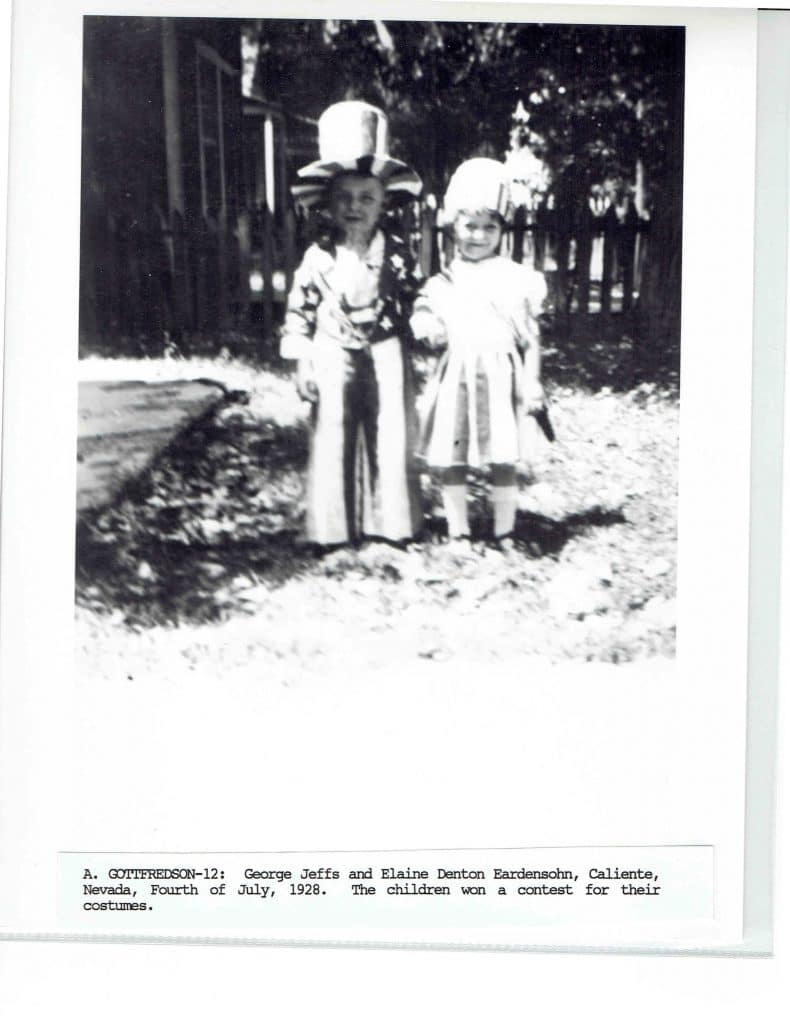 A boy in a striped Uncle Sam hat and suit stands next to a girl in a white dress.