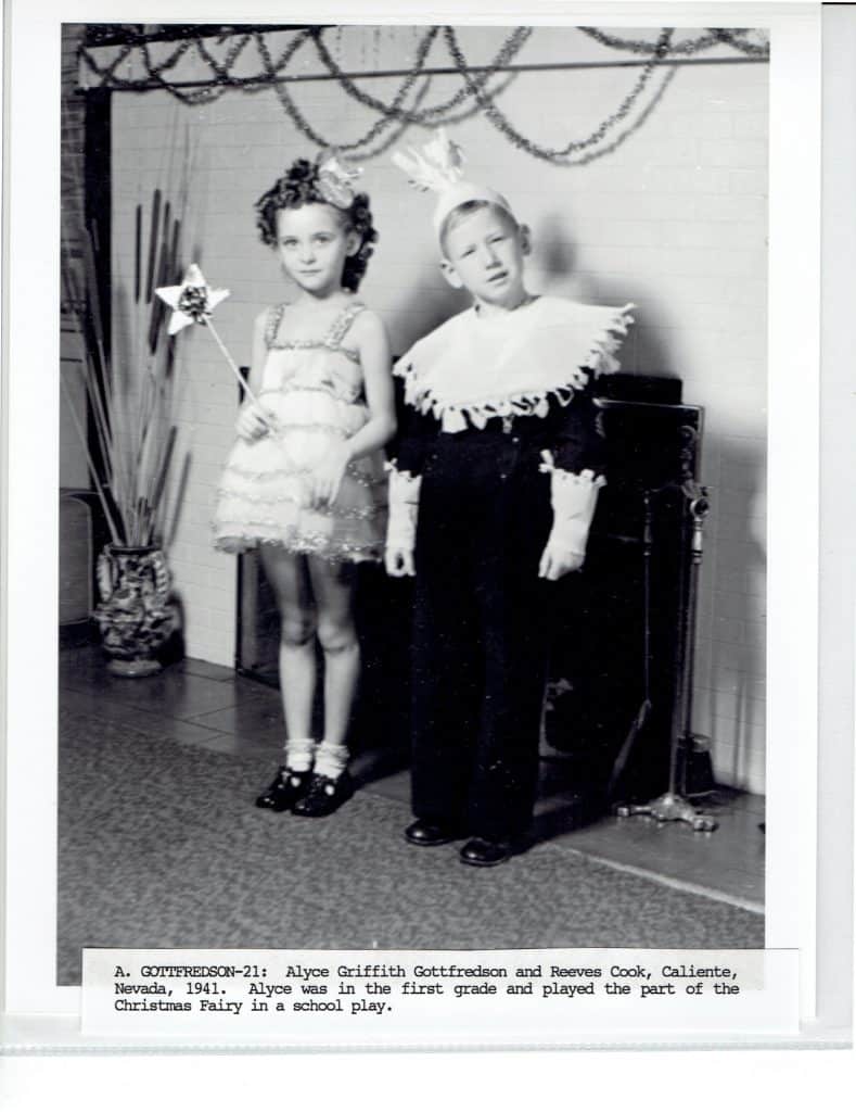 A young girl in a fairy costume holds a star wand next to a boy in a ruffled collar and crown.