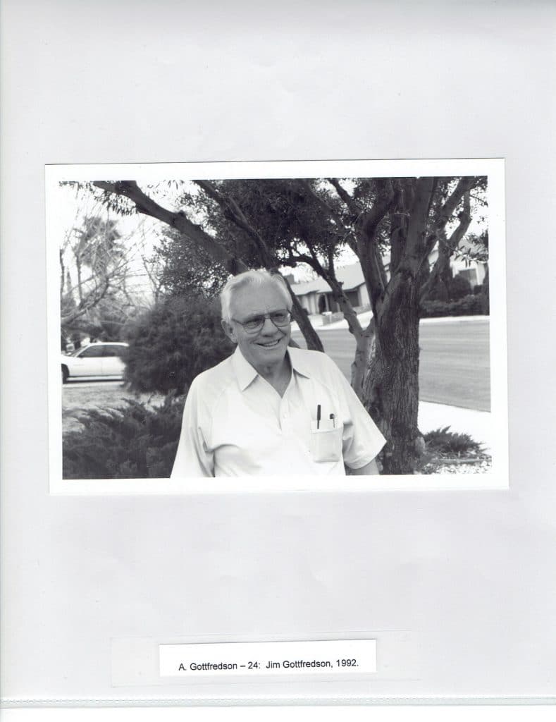 A smiling man in glasses and a short-sleeved shirt stands outdoors, with trees and a street in the background. "A. Gottfredson - 24: Jim Gottfredson, 1992."