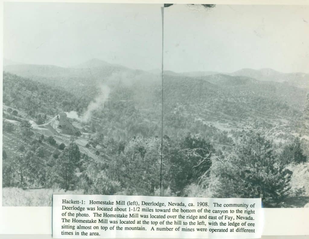 A grayscale photo of a valley with a mill and smoke rising, and text "Hackett-1: Homestake Mill (left)".