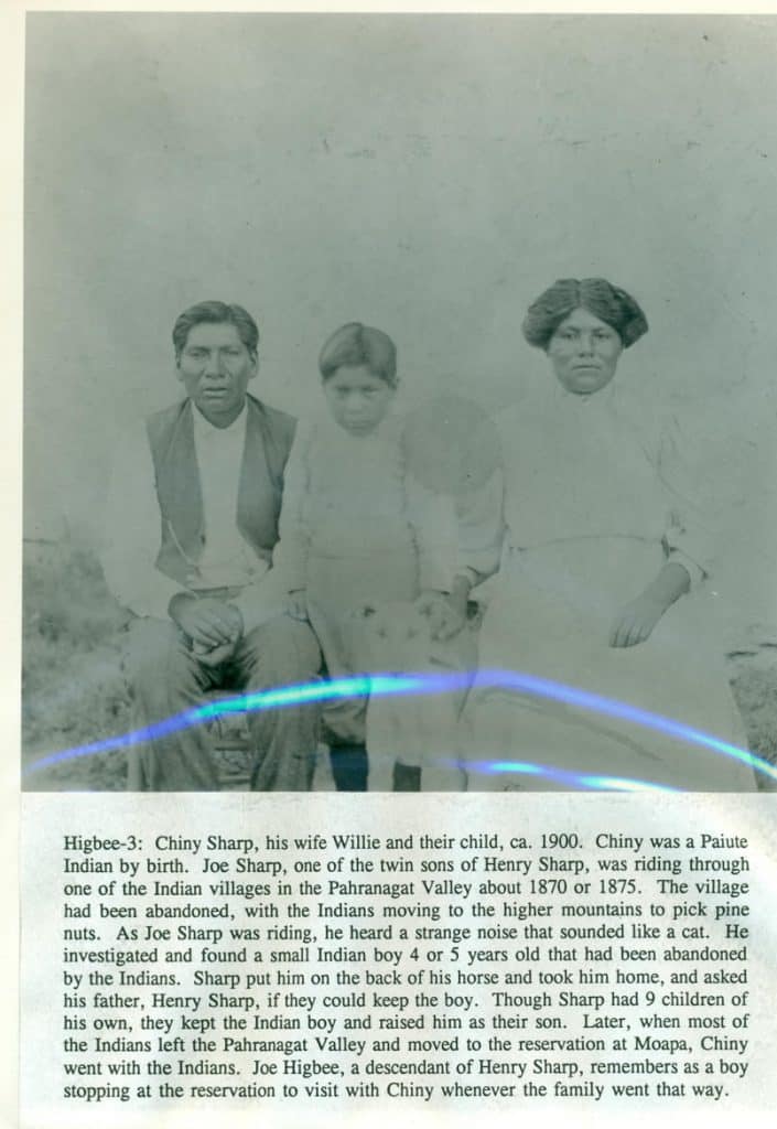 A black and white photo shows a man, woman, and child, with a blue light streak across them.