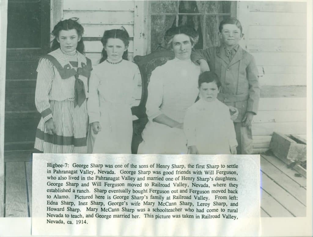 A black and white photo shows five people, two girls, a woman, and two boys, standing outside a building.