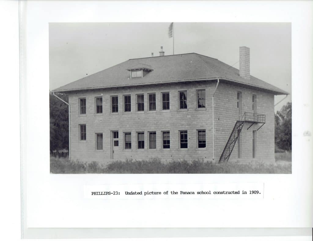 A black and white photo shows the Panaca school building with a fire escape, chimney, and flag pole.