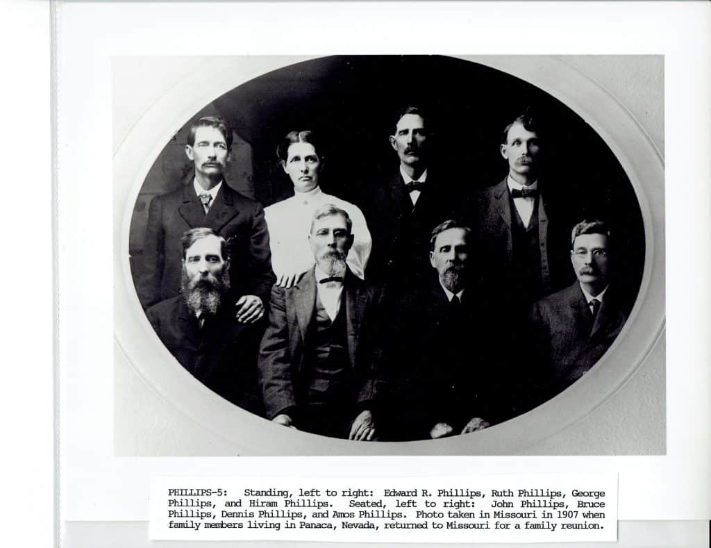 A black and white oval portrait shows seven people, six men and one woman, in formal attire.