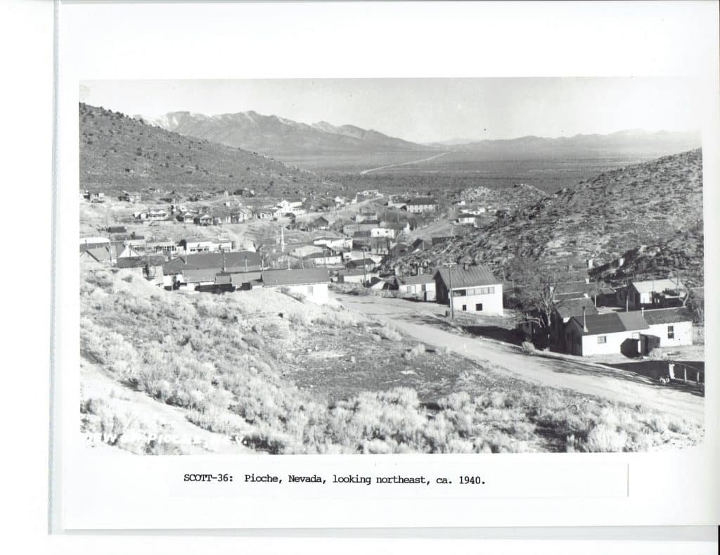 A black and white photo shows a town nestled in a valley with mountains in the distance, "SCOTT-36: Pioche, Nevada, looking northeast, ca. 1940."