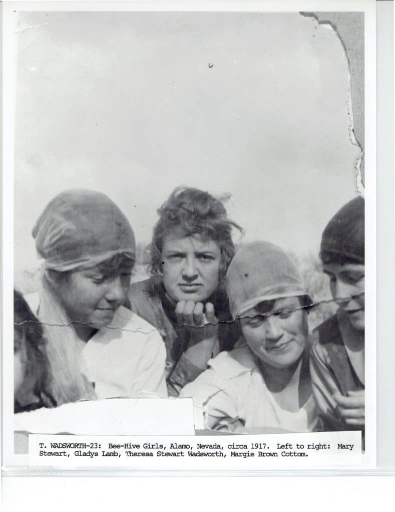 Five young women, some wearing head coverings, look down or at the camera in a faded photo.