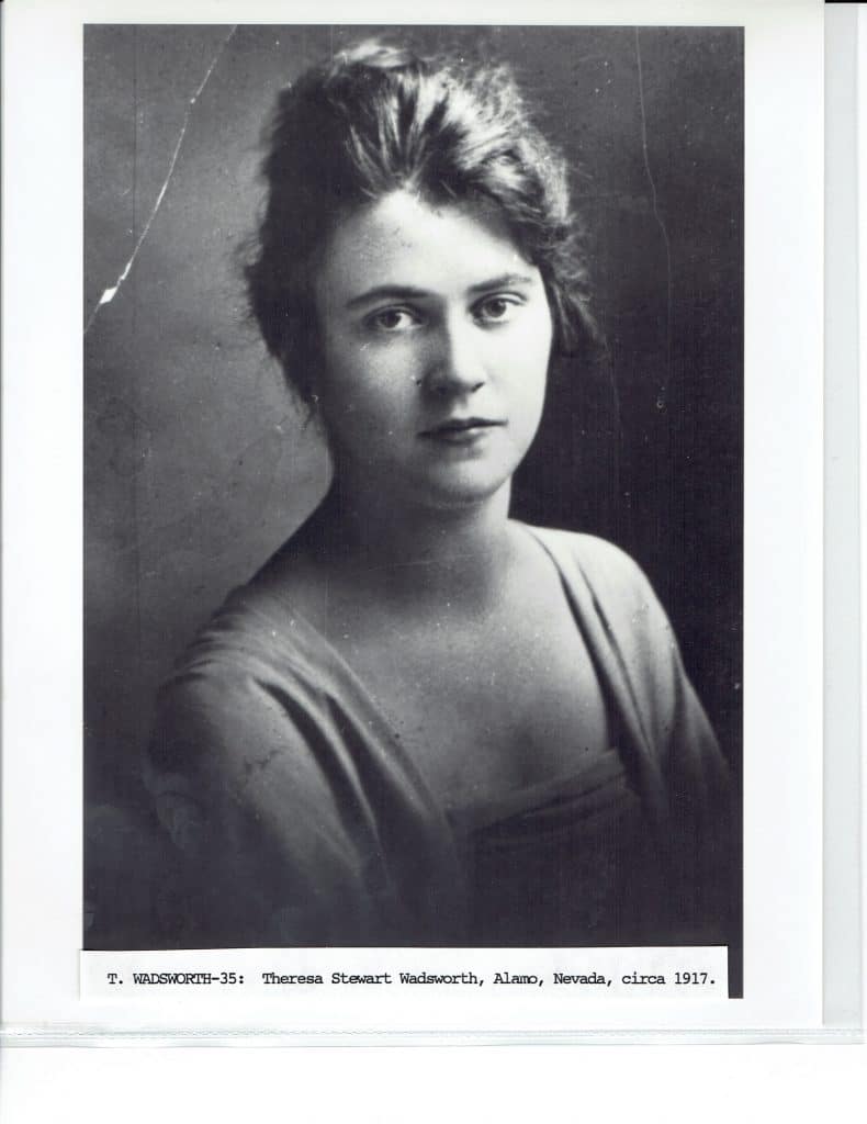 A black and white portrait shows a young woman with dark hair pulled back, wearing a light-colored dress.