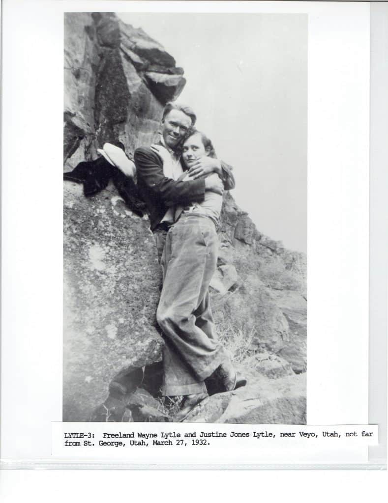A smiling man embraces a woman on a rocky hillside, with text "LYTLE-3: Freeland Wayne Lytle and Justine Jones Lytle, near Veyo, Utah, not far from St. George, Utah, March 27, 1932."