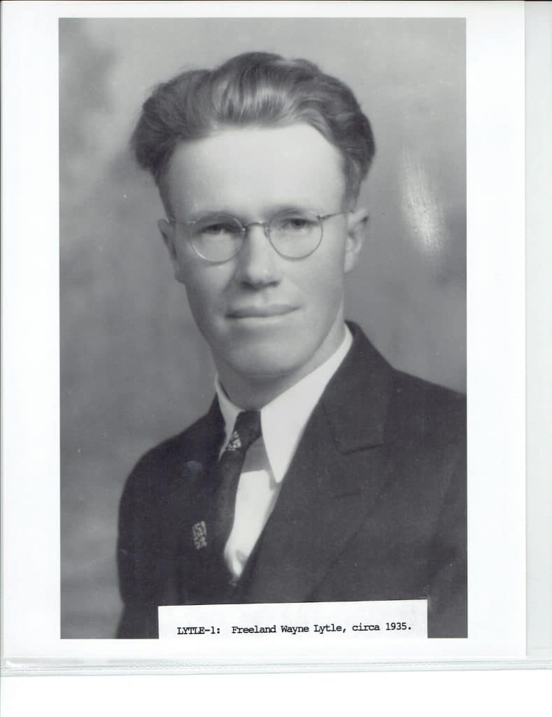 A black and white portrait of a young man with glasses, wearing a suit and tie. "LYTLE-1: Freeland Wayne Lytle, circa 1935."